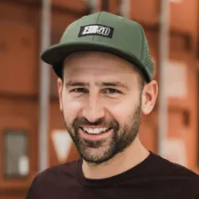 Portraitfoto von lächelndem Mann mit grauem Cap und Bart